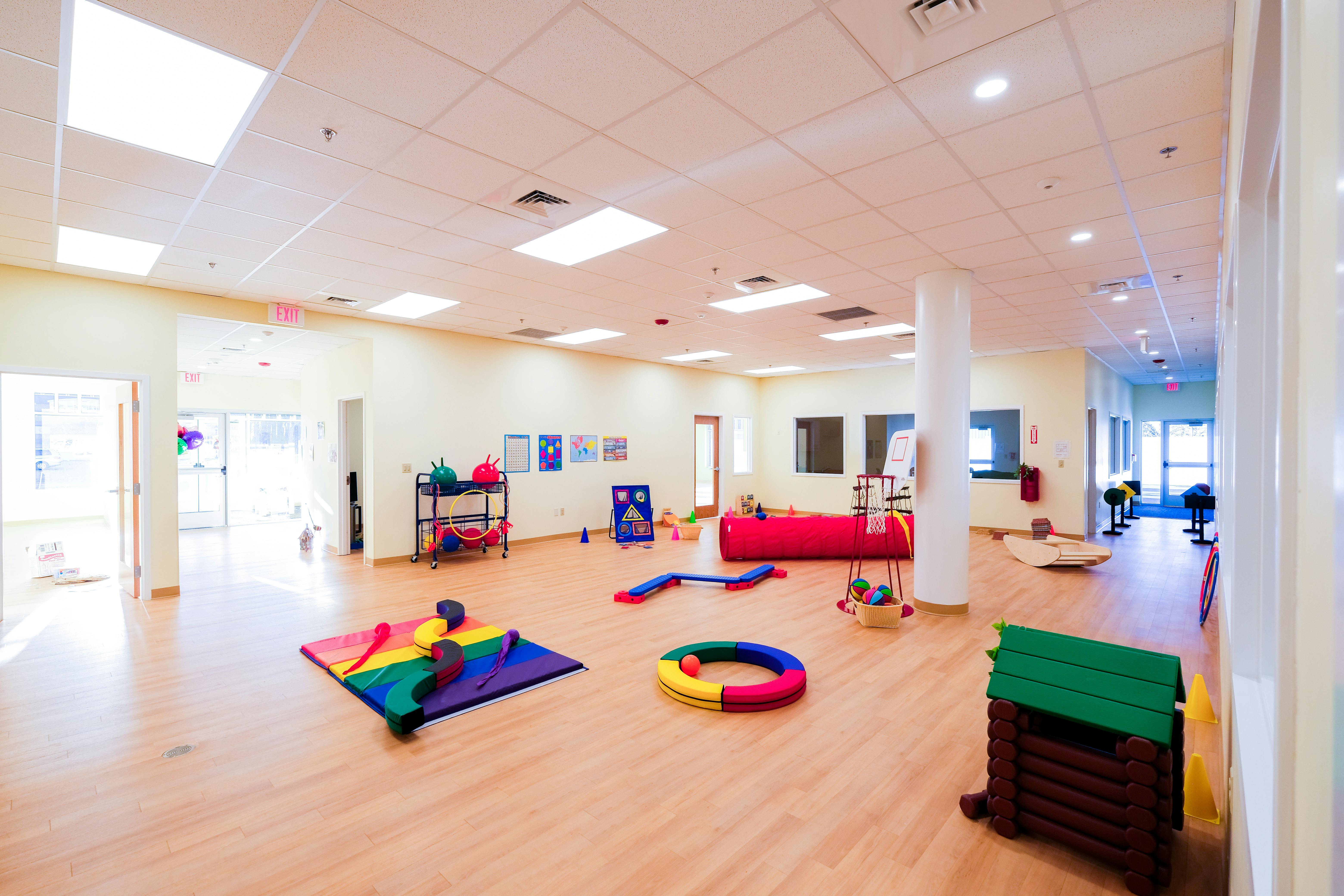Playroom with colorful mats and toys on a wooden floor