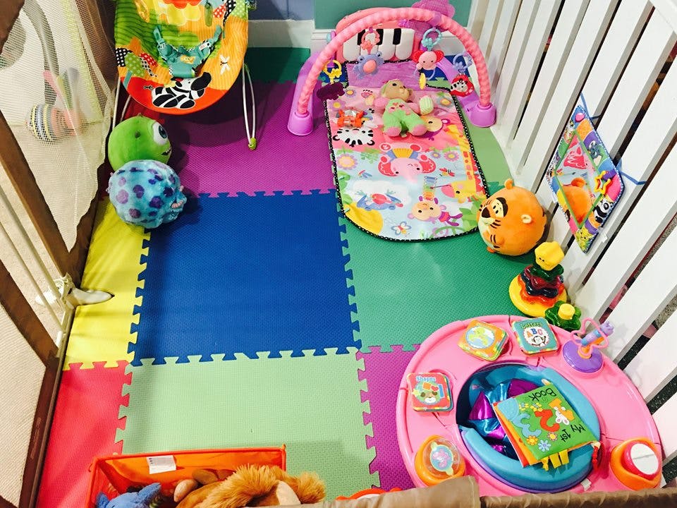 Play area with colorful foam mats and various baby toys