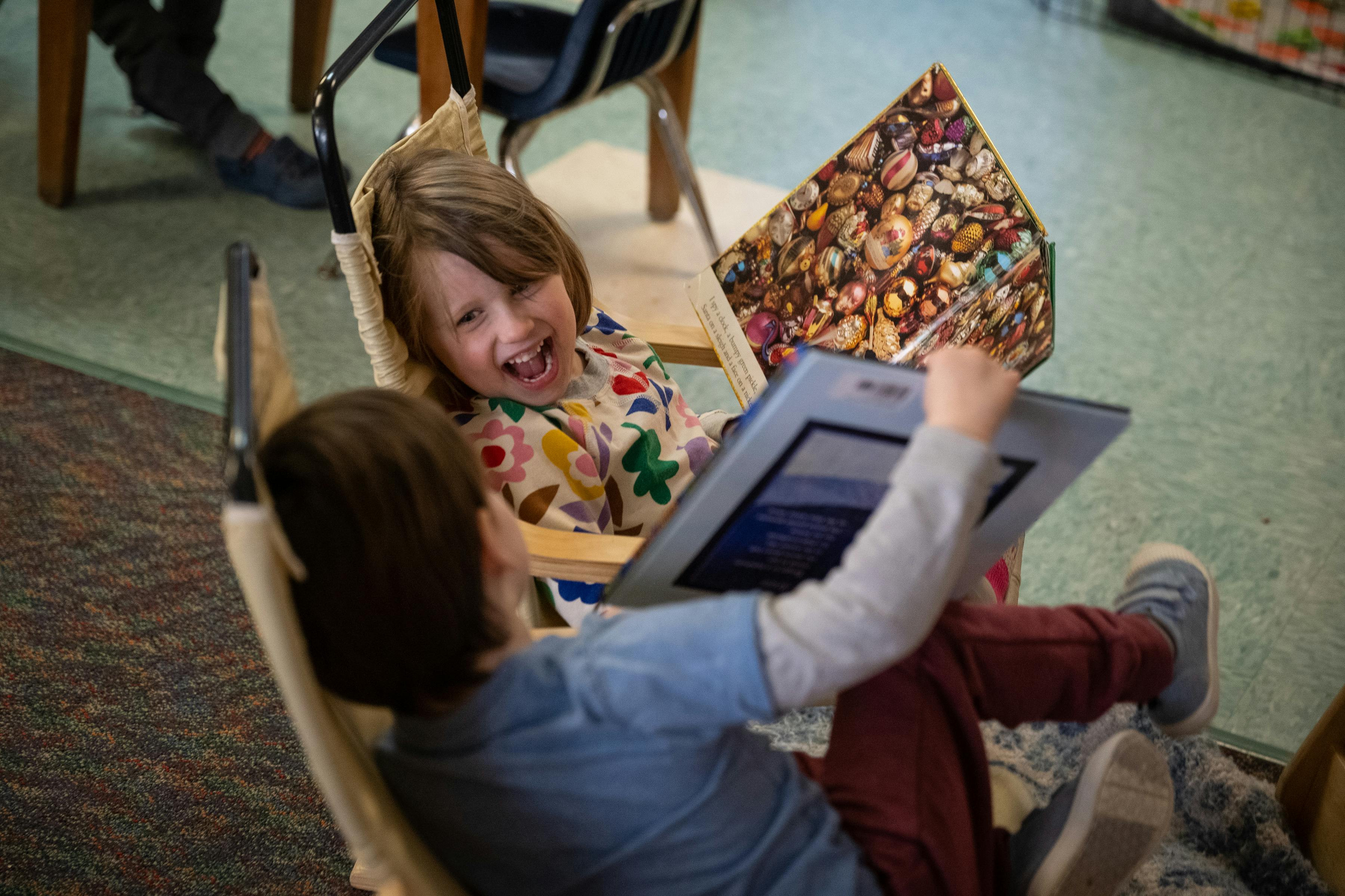 Two children reading a book together in a classroom
