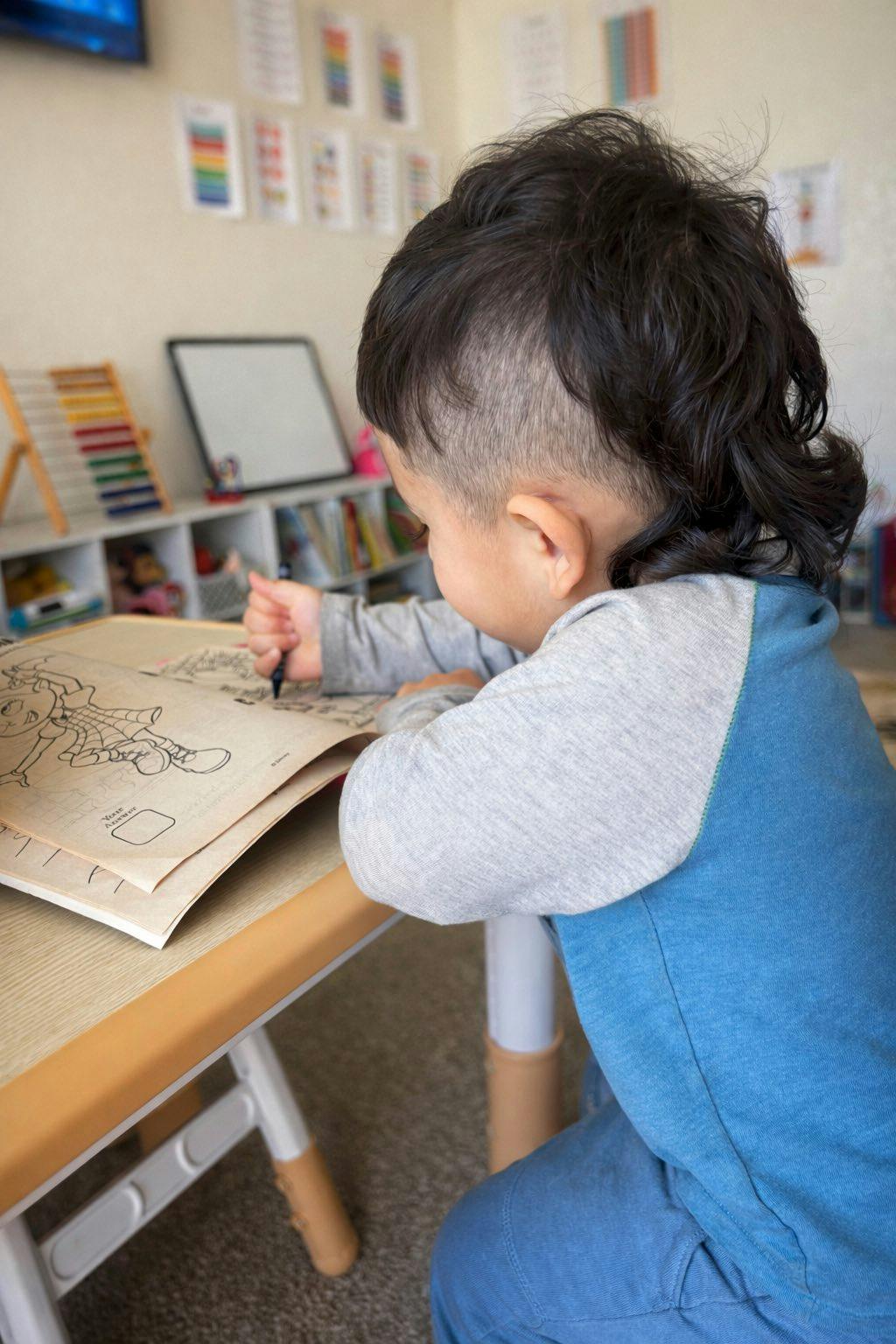 Child coloring in a book at a table