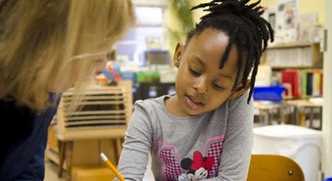 Adult and child looking at something in a classroom