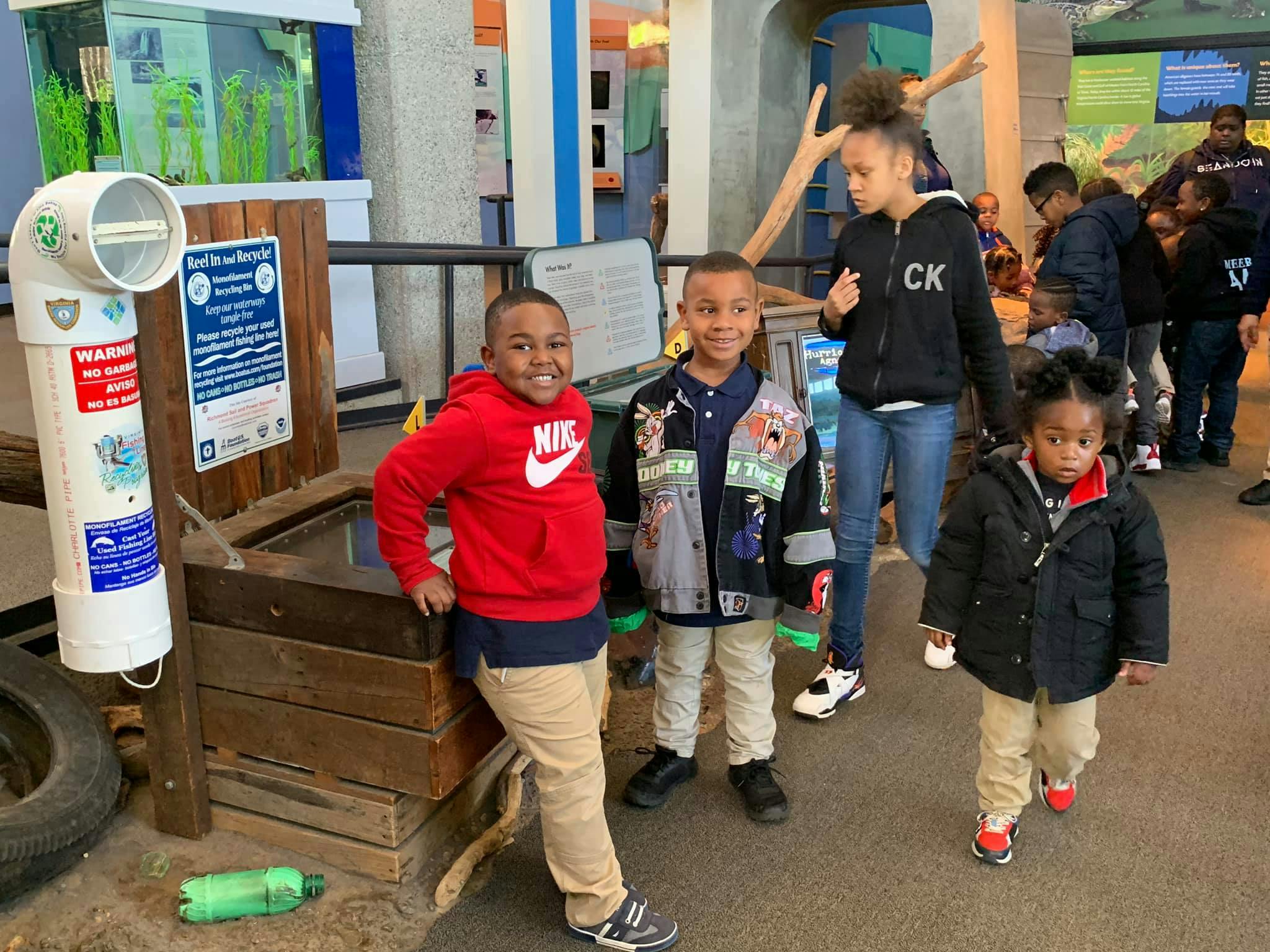 Four children standing in an indoor exhibit area