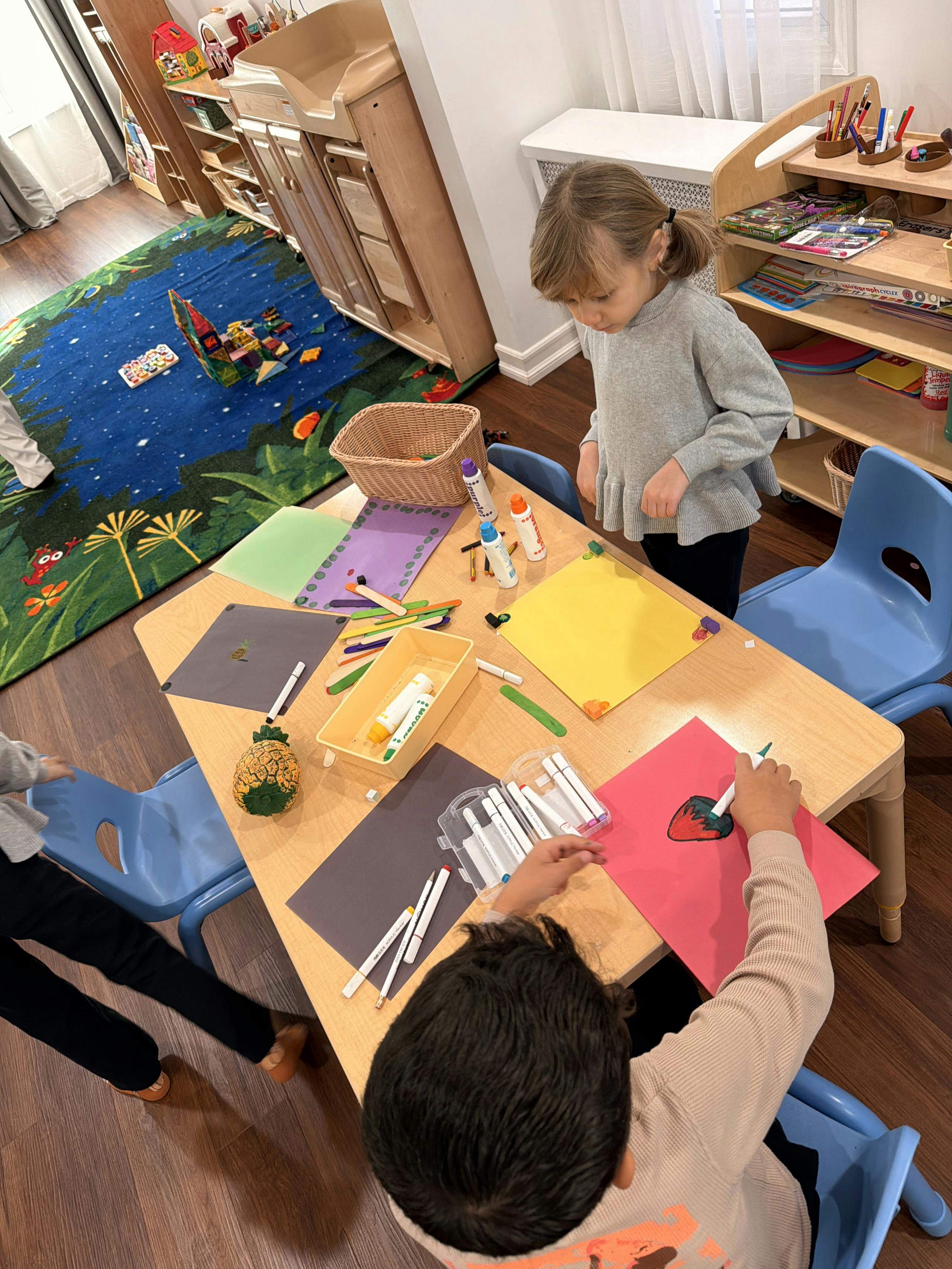 Children doing crafts at a table in a classroom