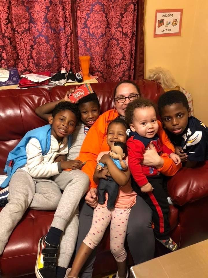 Adult and five children sitting on a couch