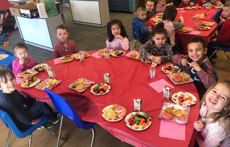 Children sitting at a table with food