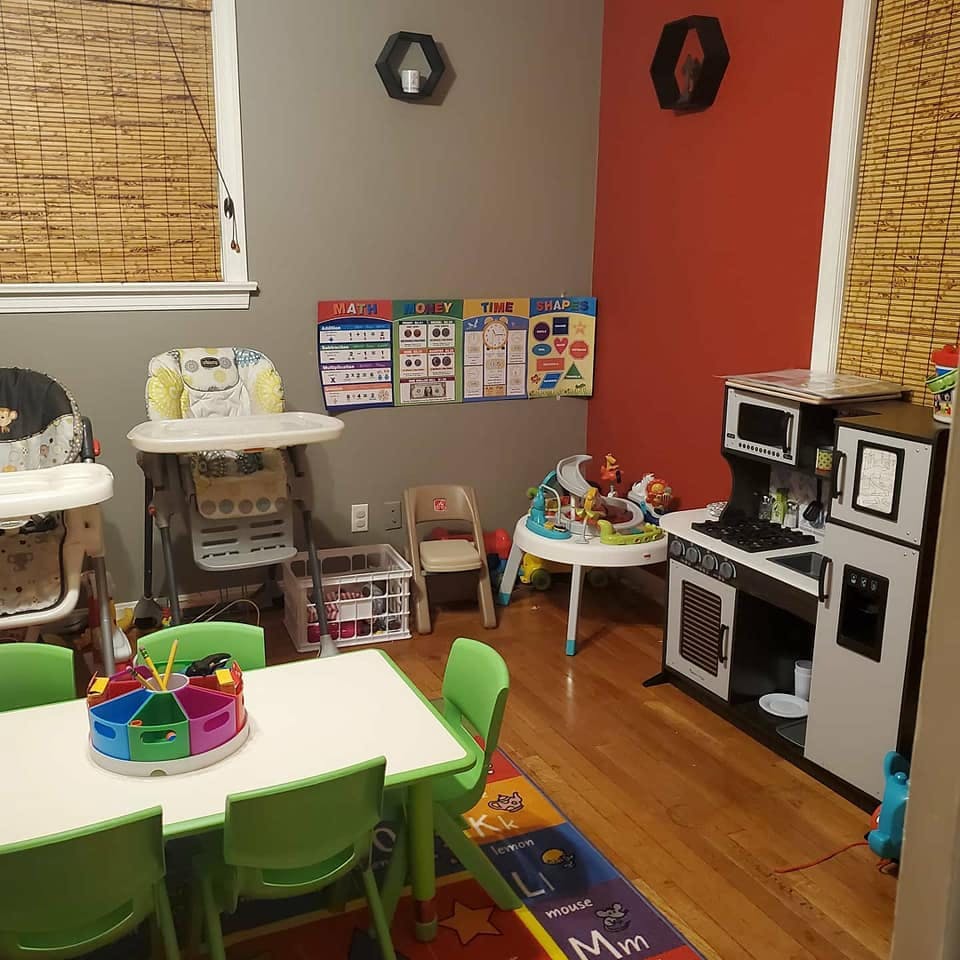 Children's play area with a table and chairs, high chairs, and play kitchen