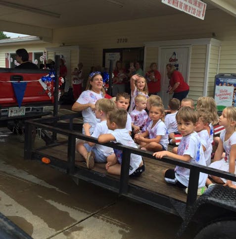 Adult and children on a trailer attached to a truck