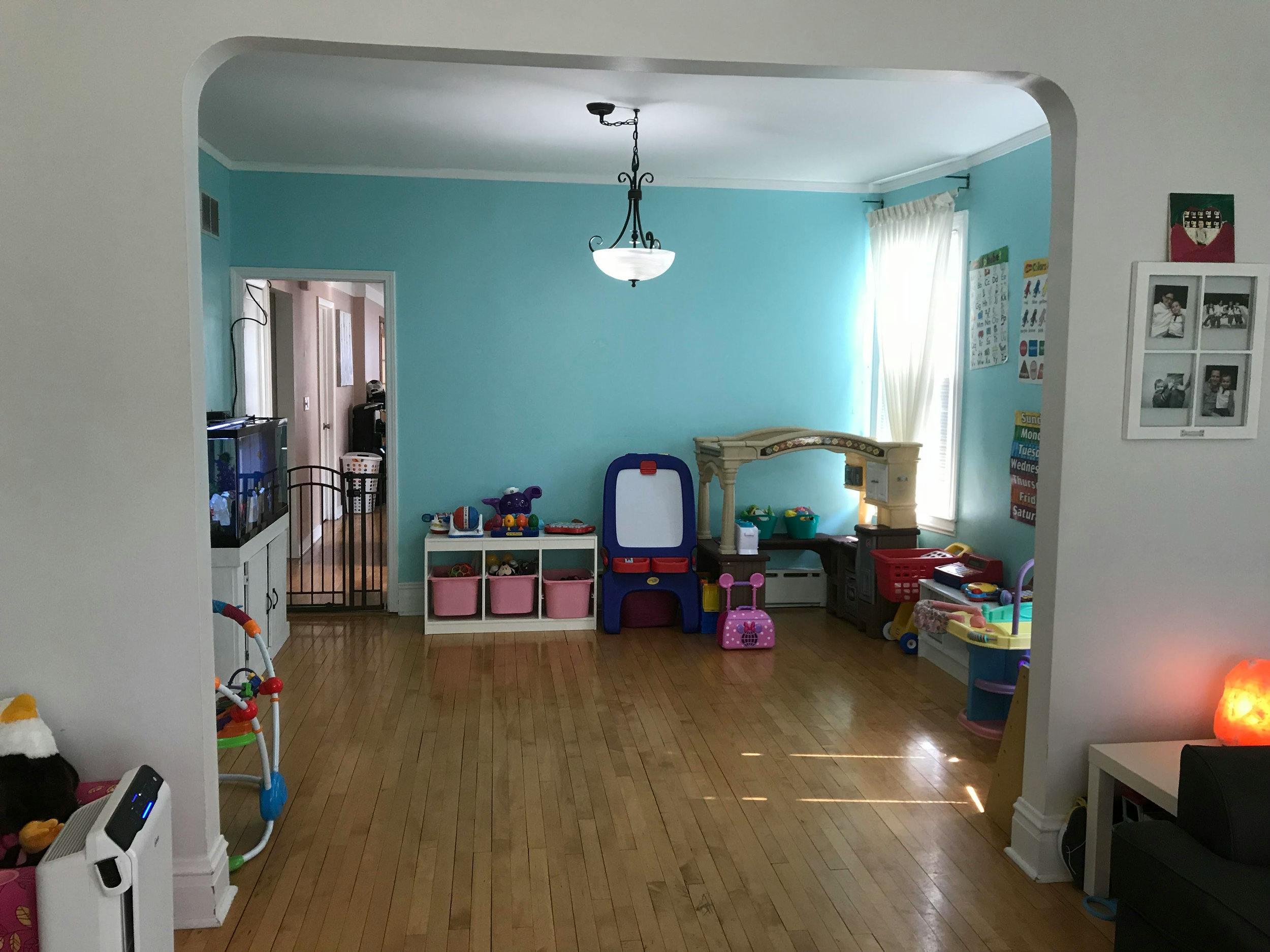 Room with light blue walls and hardwood floor, children's toys and furniture
