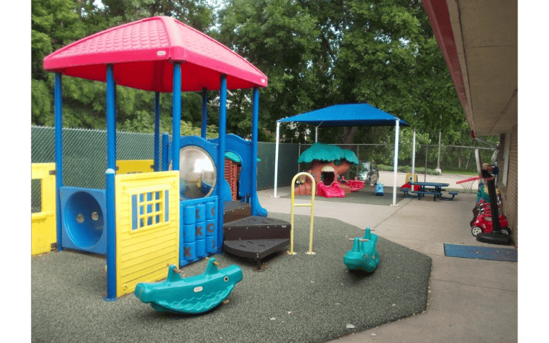 Colorful playground equipment with slides, tunnels, and animal rockers