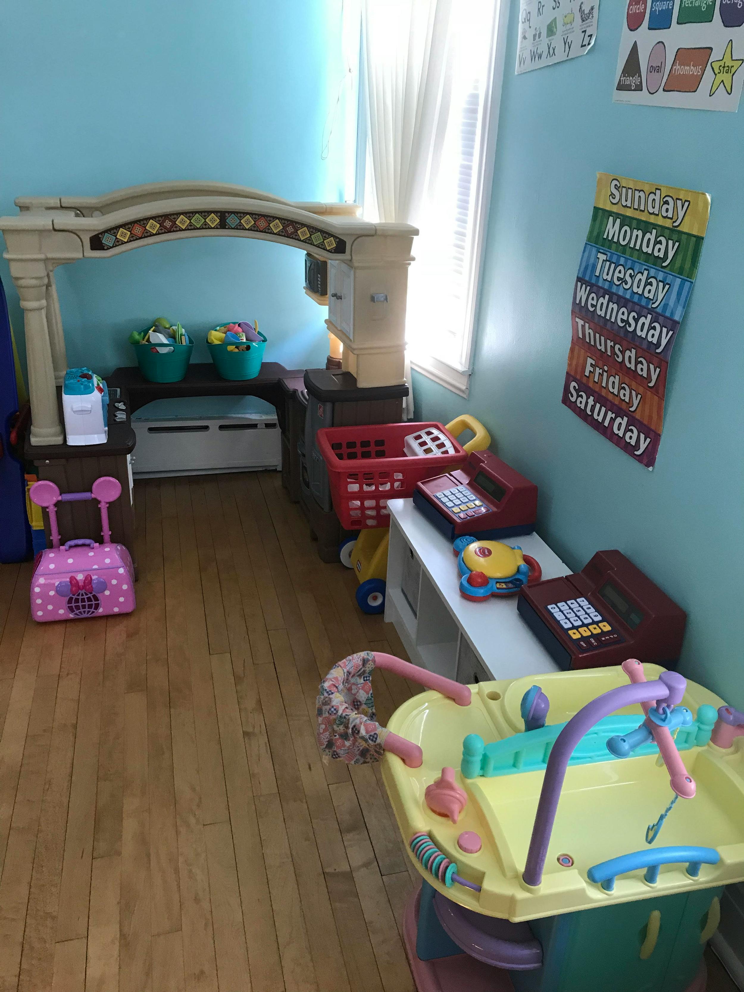 Playroom with various toys, including a play kitchen and shopping cart