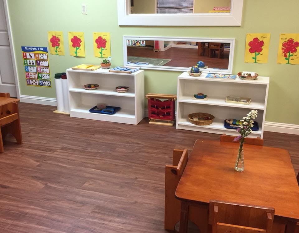 Classroom with small tables and shelves with learning materials