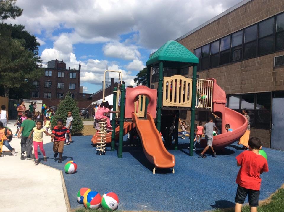 Children playing on a playground with slides and climbing structures