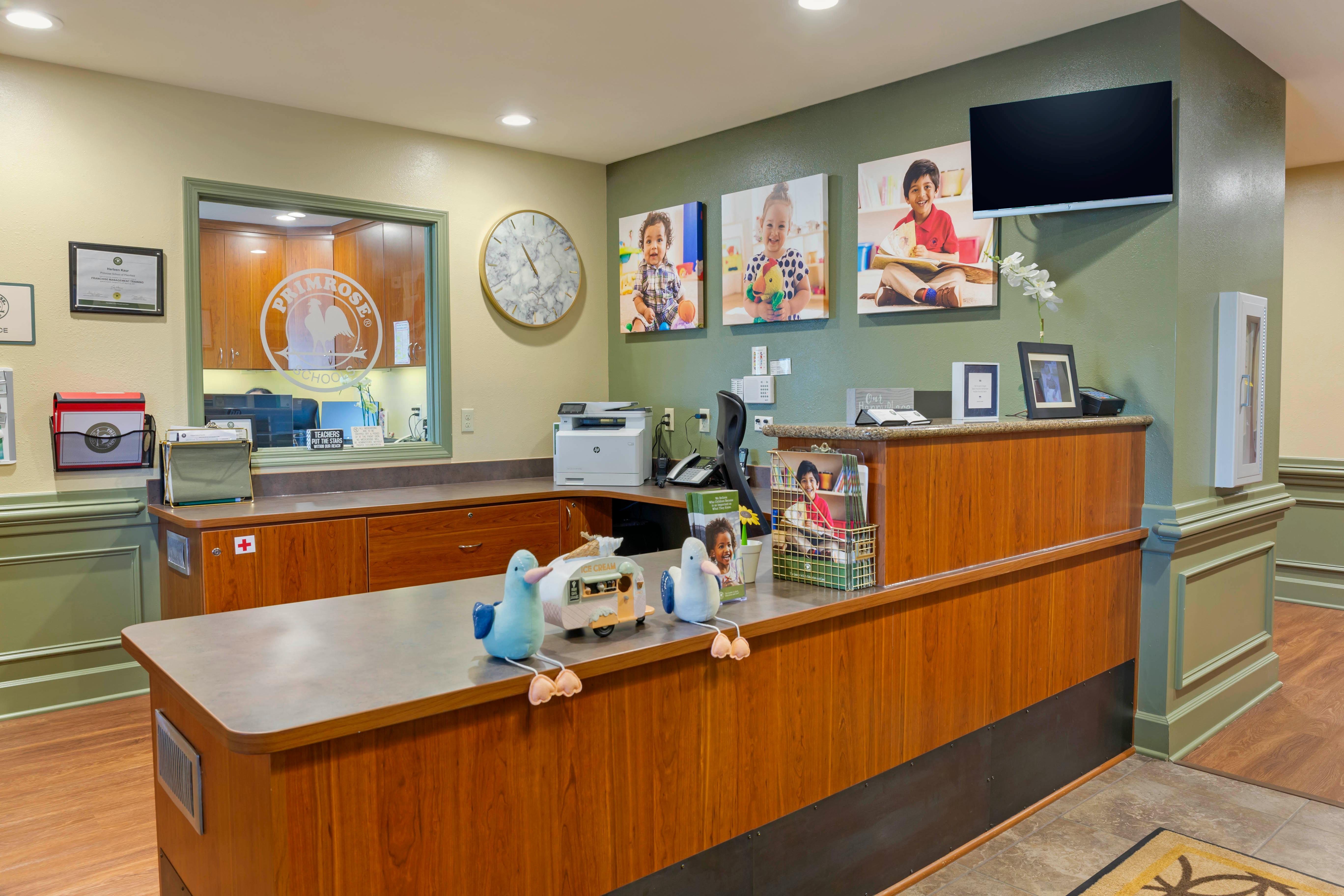 Reception desk with office equipment and child photos on the wall