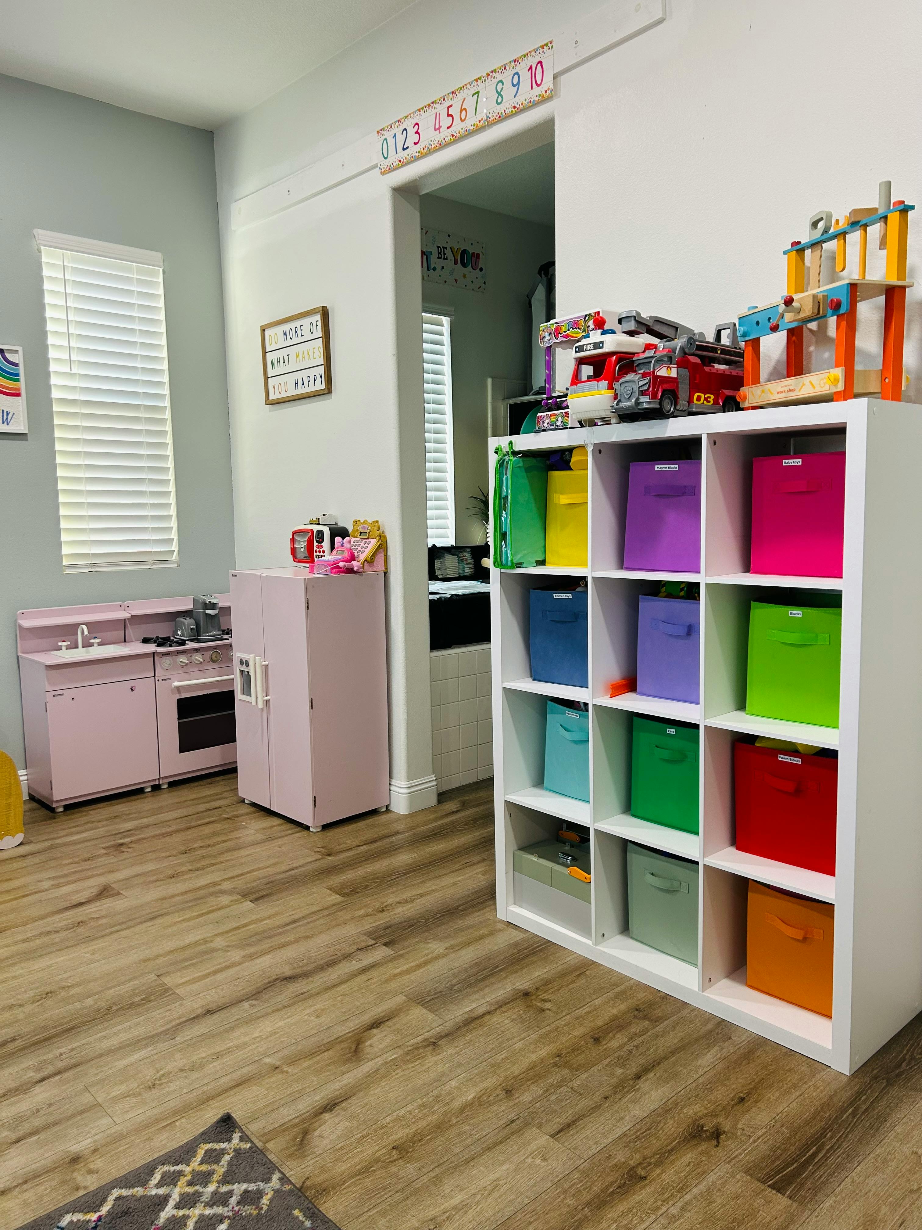 Playroom with toy kitchen and storage shelf with colorful bins