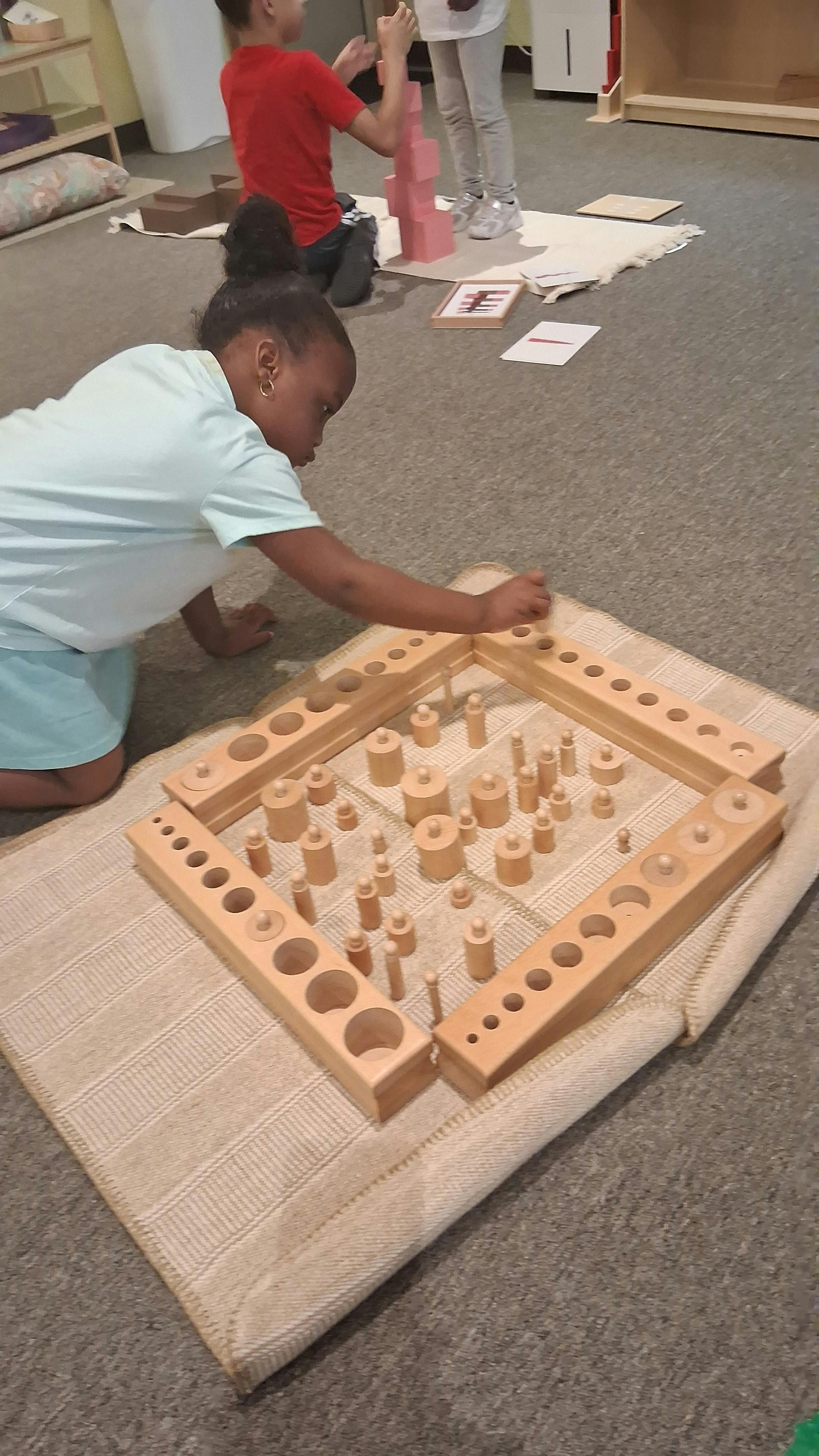 Child playing with wooden cylinder blocks on a mat