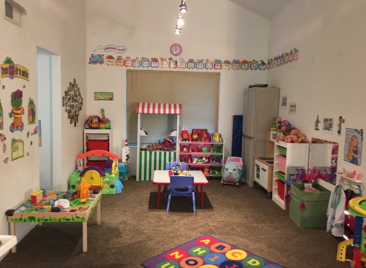 Playroom with various toys, tables, and a striped play stand