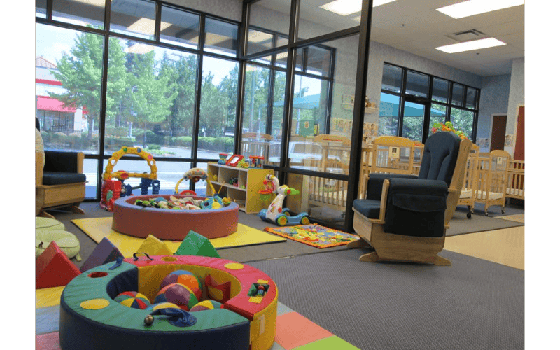 Childcare playroom with ball pits, play mats, and cribs