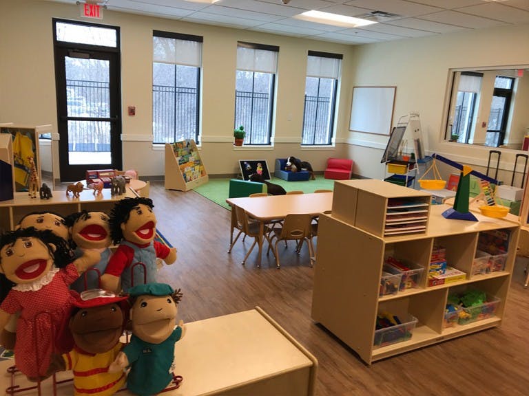 Classroom with puppets, tables, and shelves
