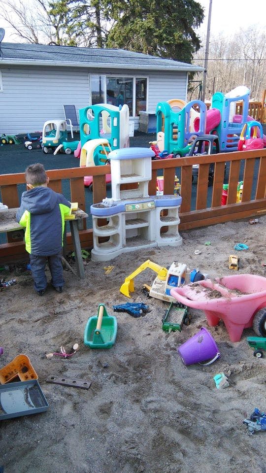 Child playing in a sandbox with toys