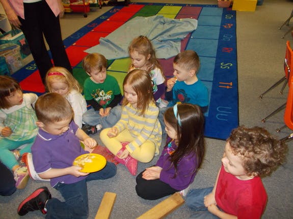 Group of children sitting on a rug in a classroom