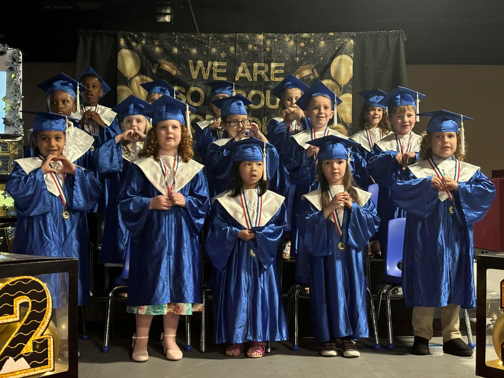 Group of children in blue graduation caps and gowns