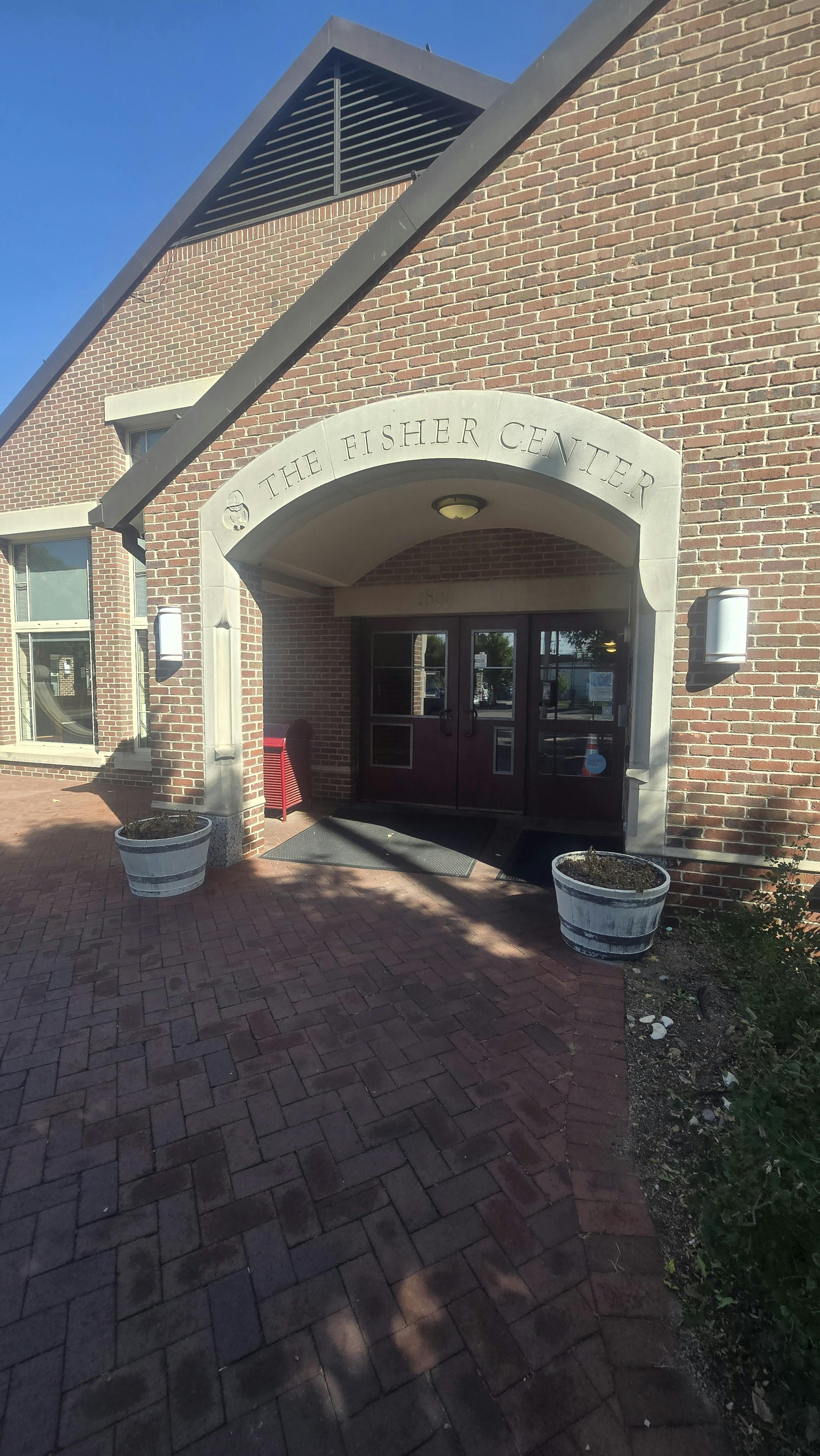 Brick building entrance with an arched doorway and "THE FISHER CENTER" inscribed