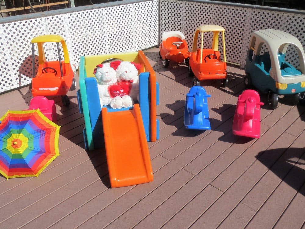 Playground with a slide, toy cars, and a colorful umbrella