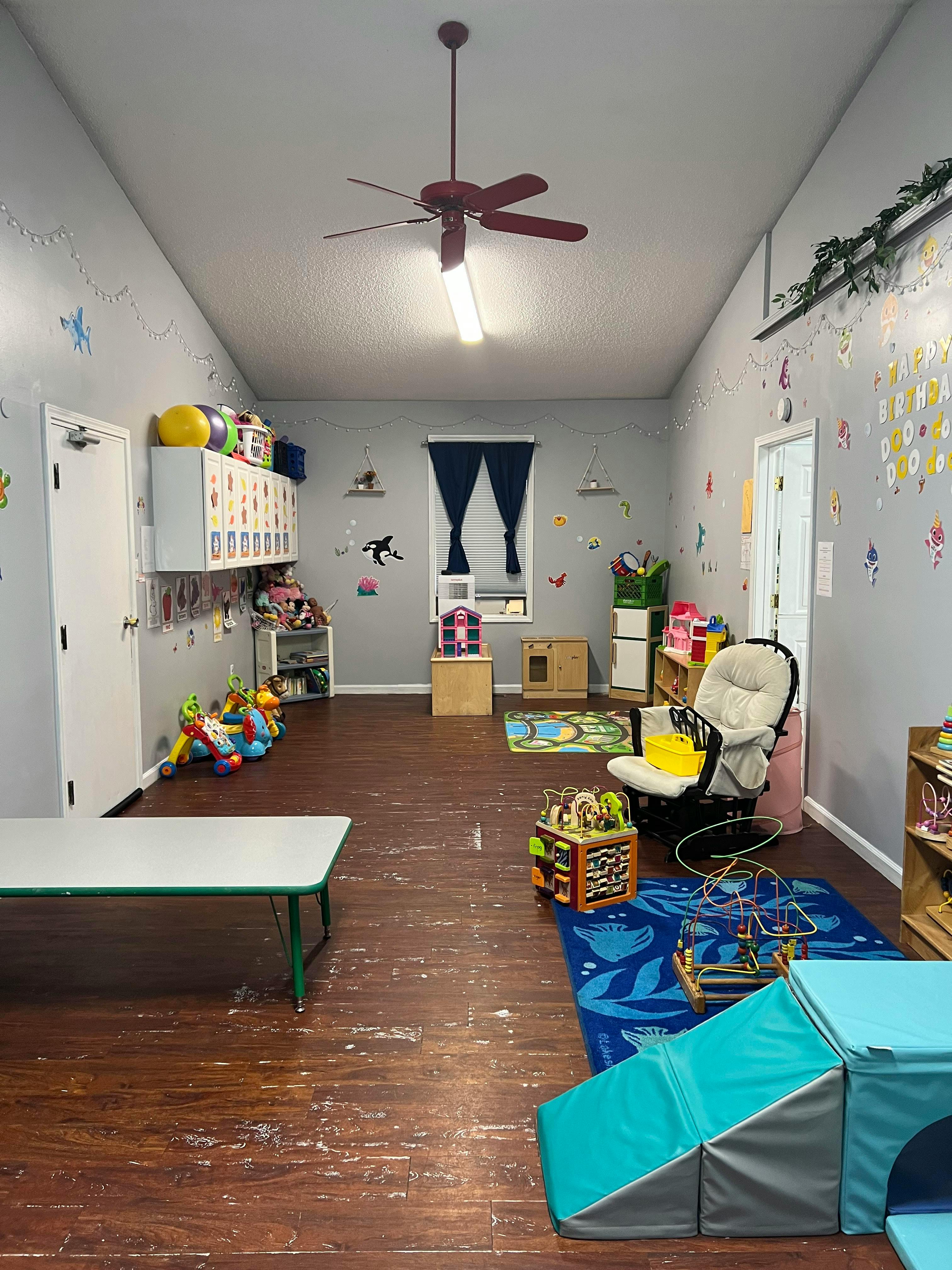 Playroom with toys, small table, and ceiling fan