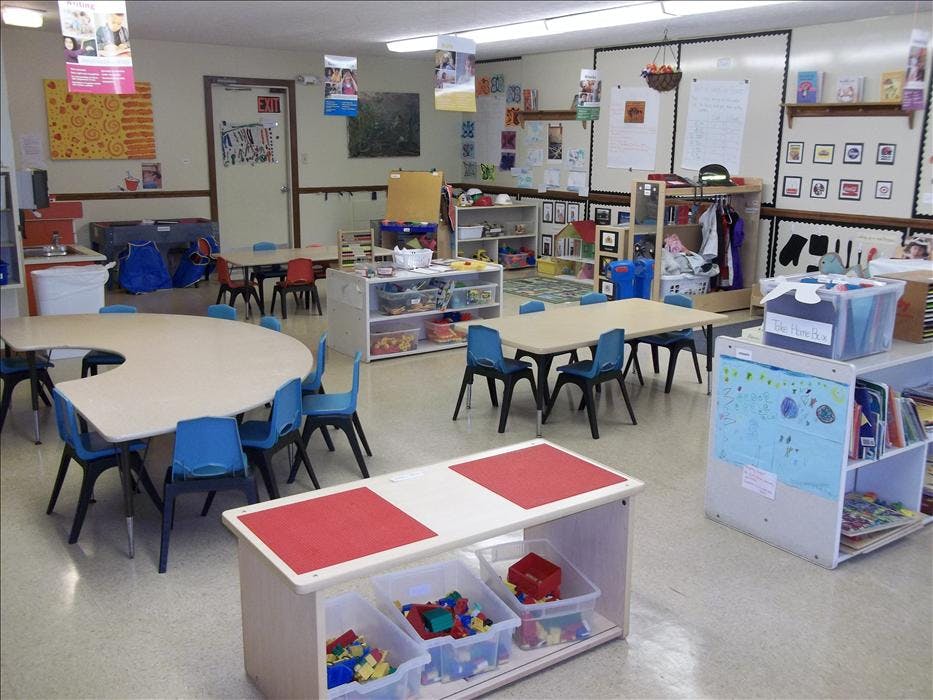 Classroom with tables, chairs, and shelves