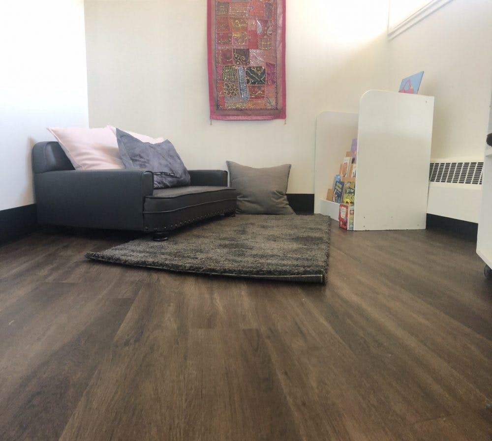 Sofa with pillows and a rug on a wooden floor
