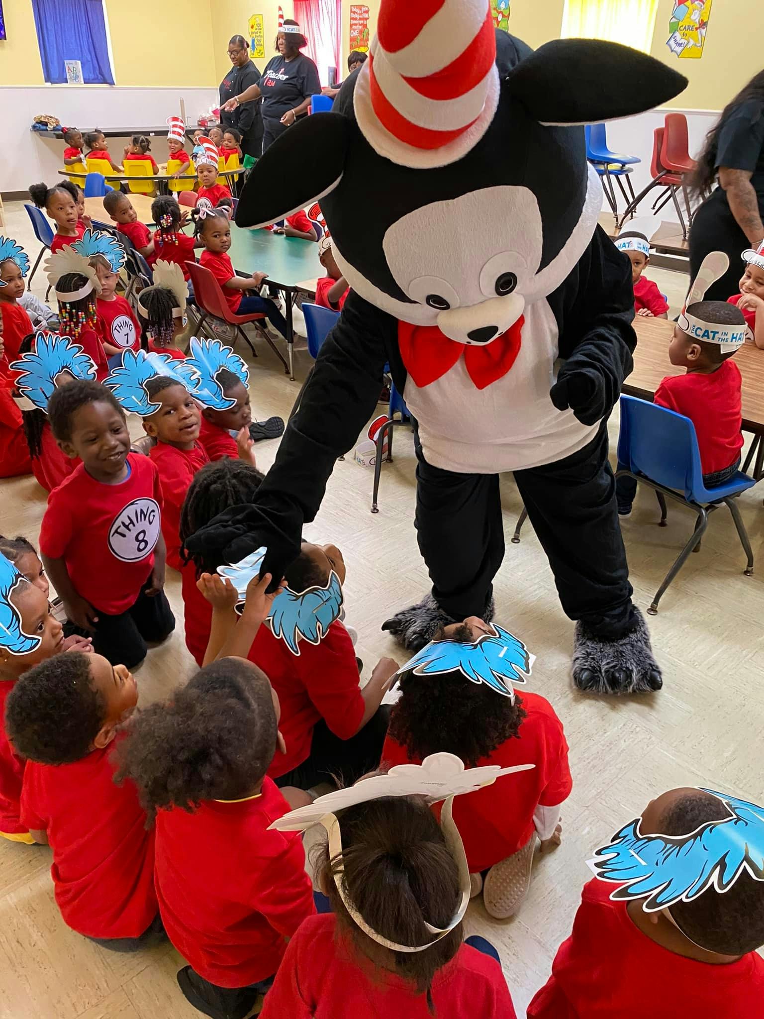 Person in Cat in the Hat costume interacting with children in a classroom