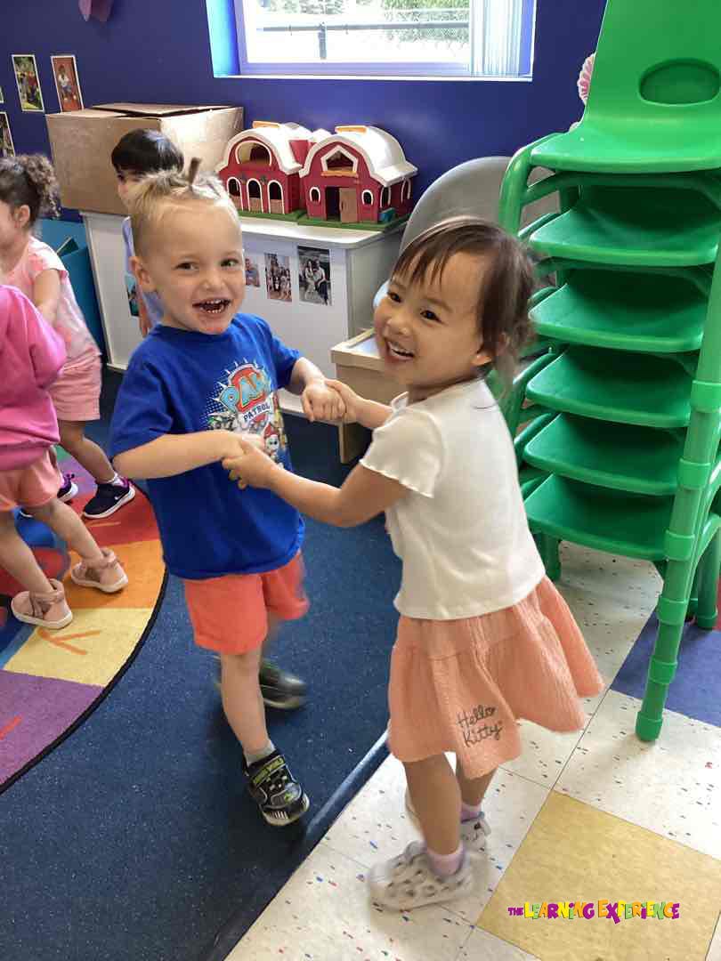 Two children holding hands and smiling