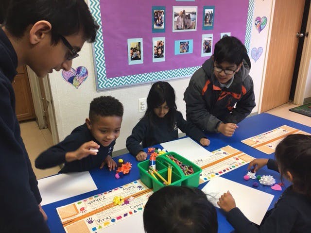 People and children gathered around a table with art supplies