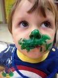 Child with green paint on face