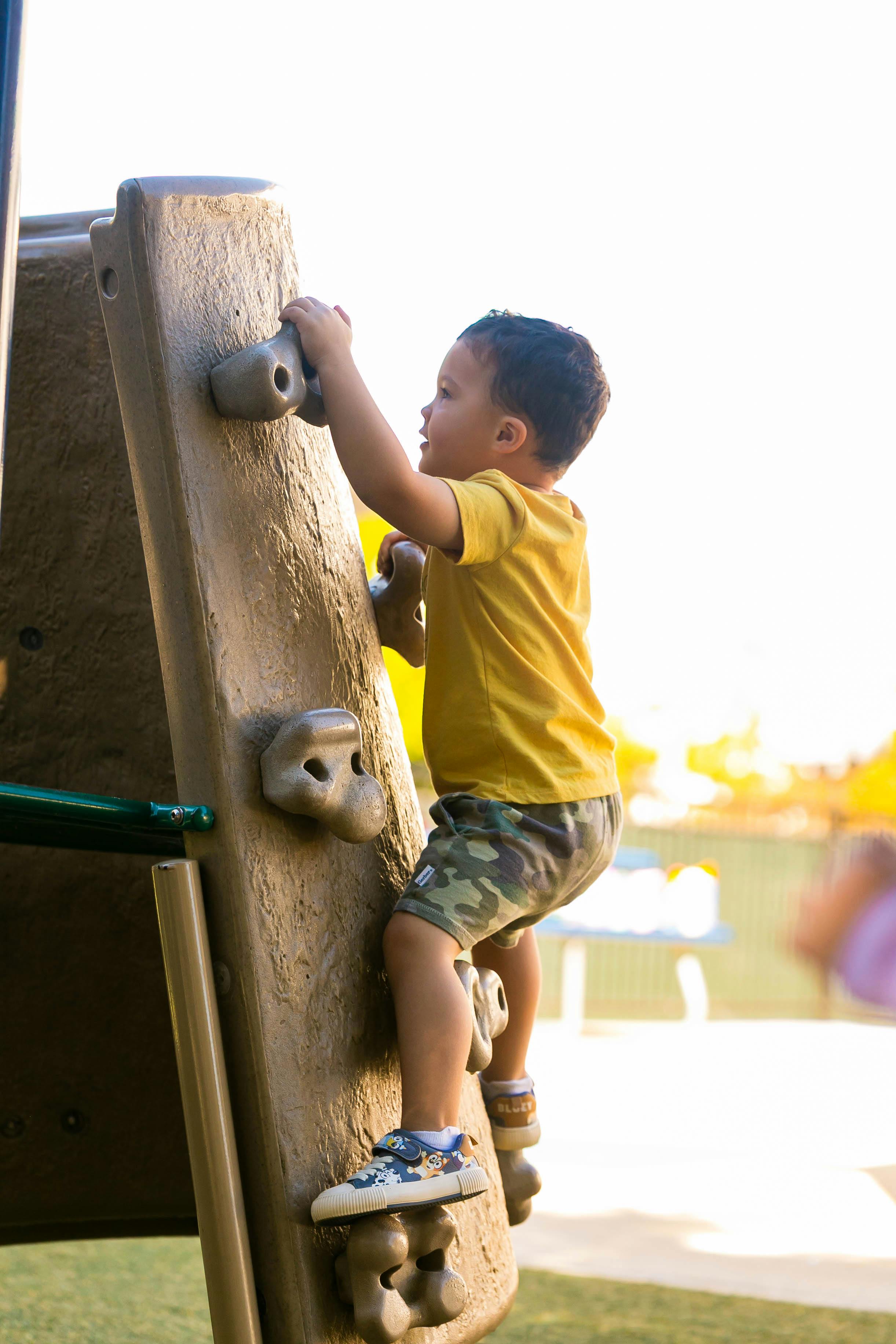 Child climbing a rock wall on a playground
