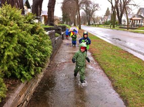 Children walking on a wet sidewalk