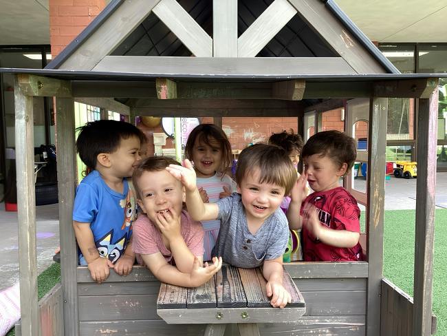 Group of children playing in a wooden playhouse