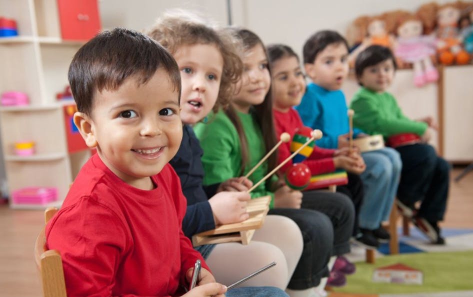 Children sitting in a row holding musical instruments