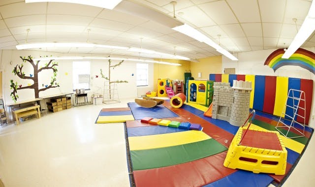 Indoor play area with colorful mats and play structures