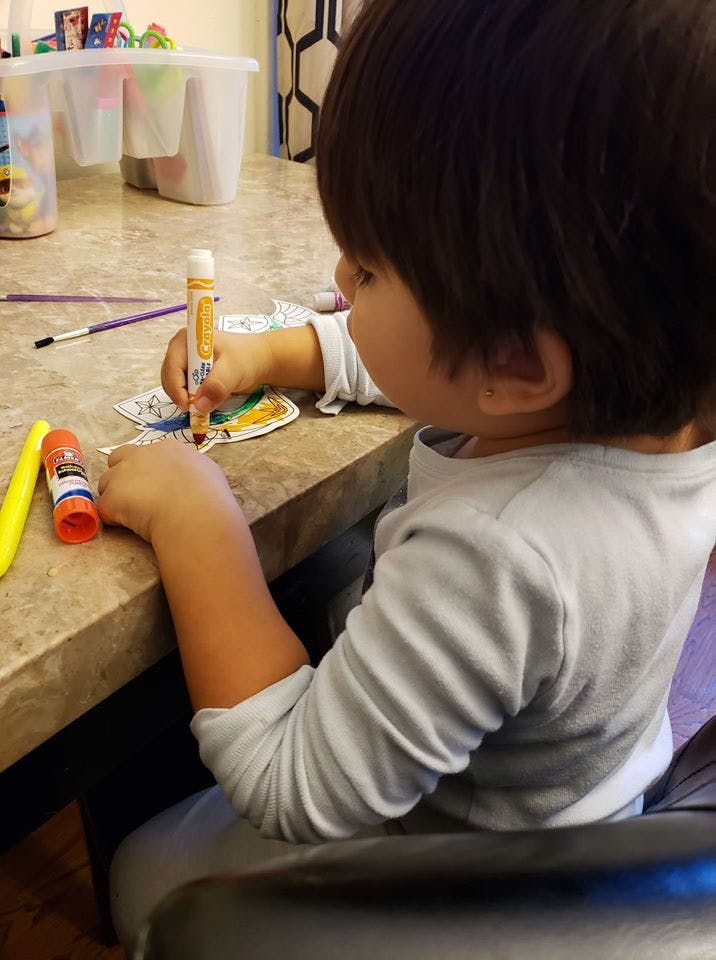 Child coloring with a marker at a table