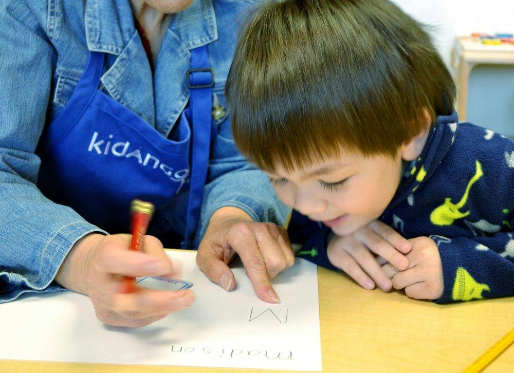 Person and child writing on paper