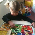 Child playing with a busy board