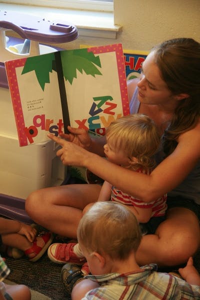 Person reading an alphabet book to a child