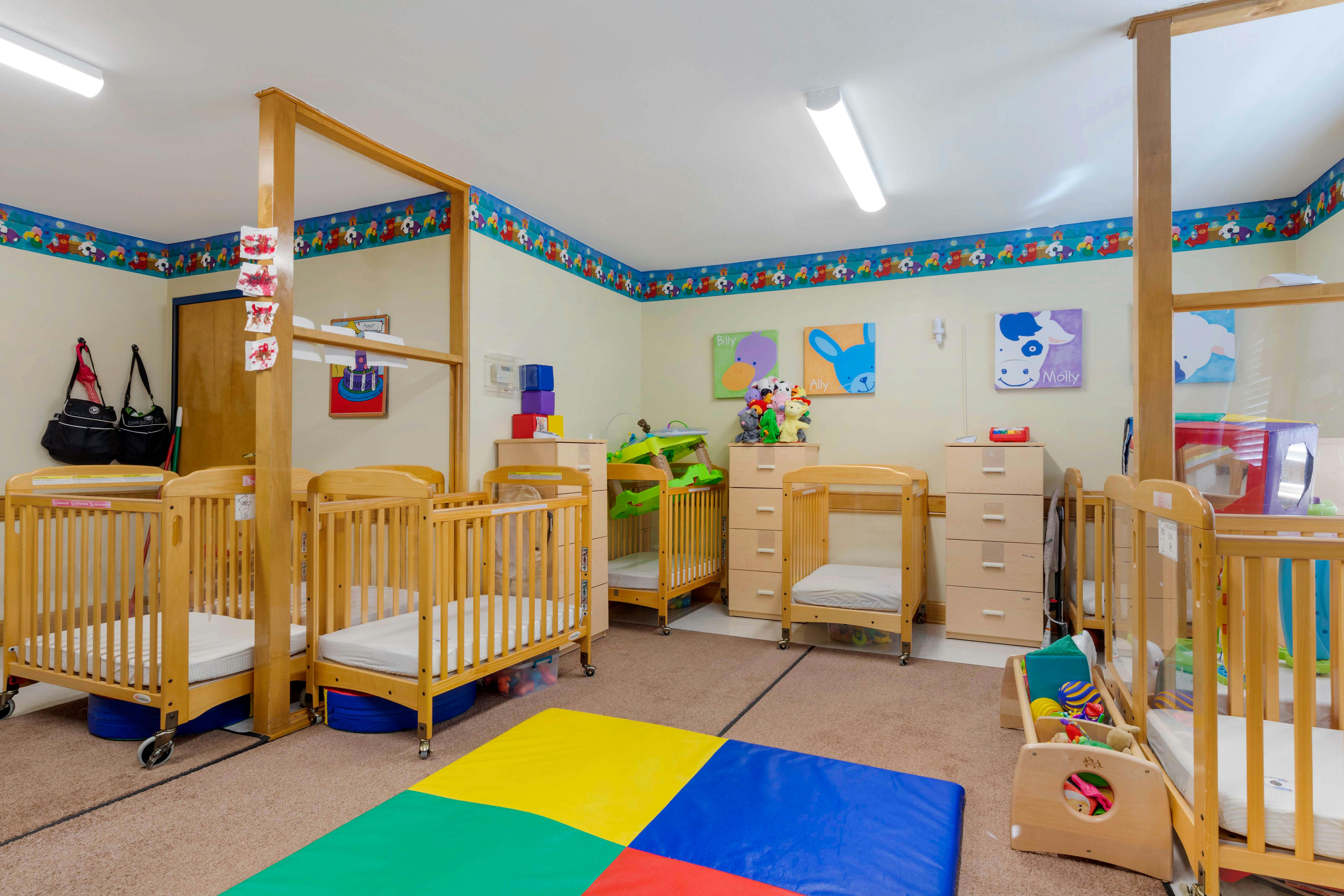Cribs and playmats in a bright daycare room