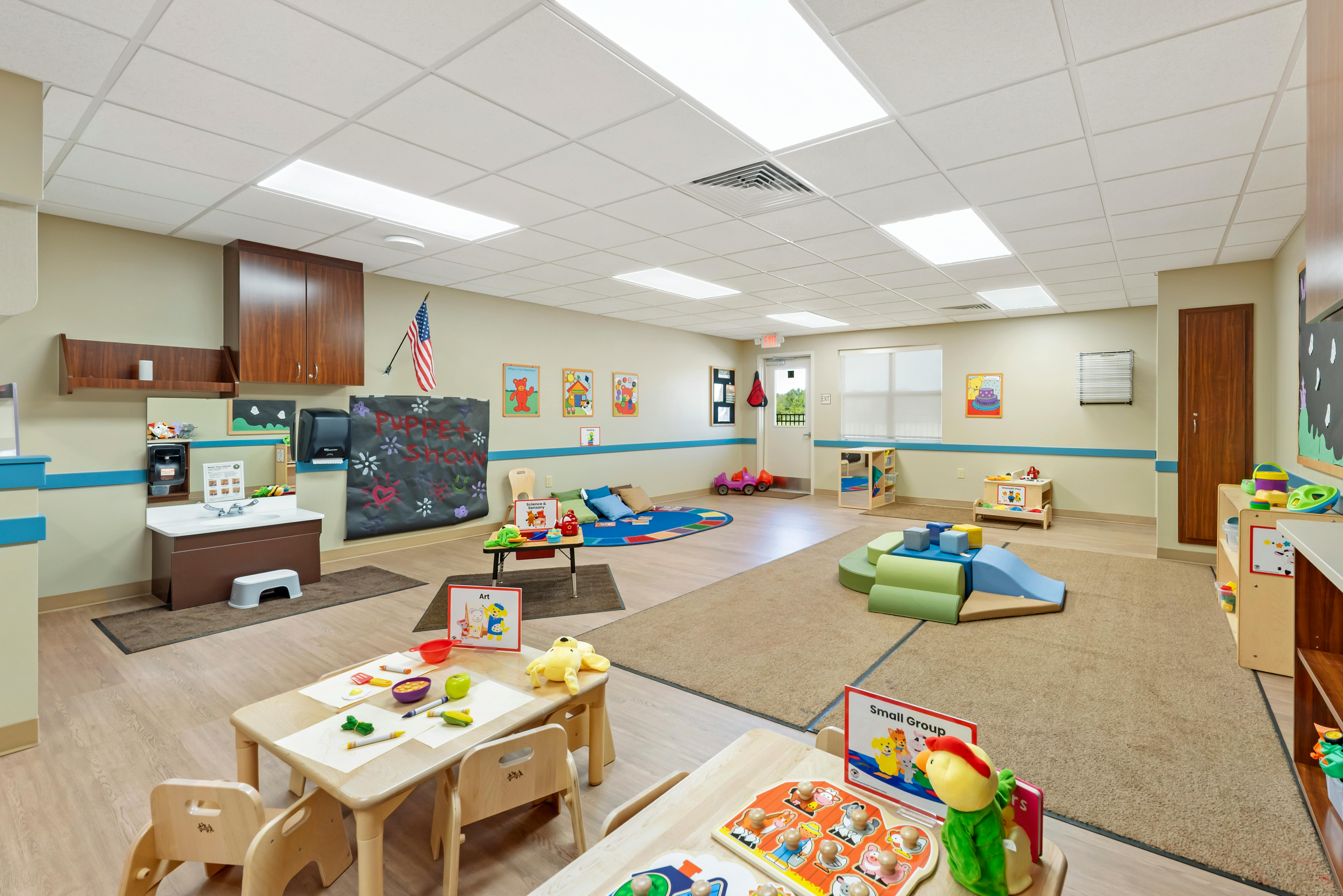 A colorful early childhood classroom with activity areas and small tables