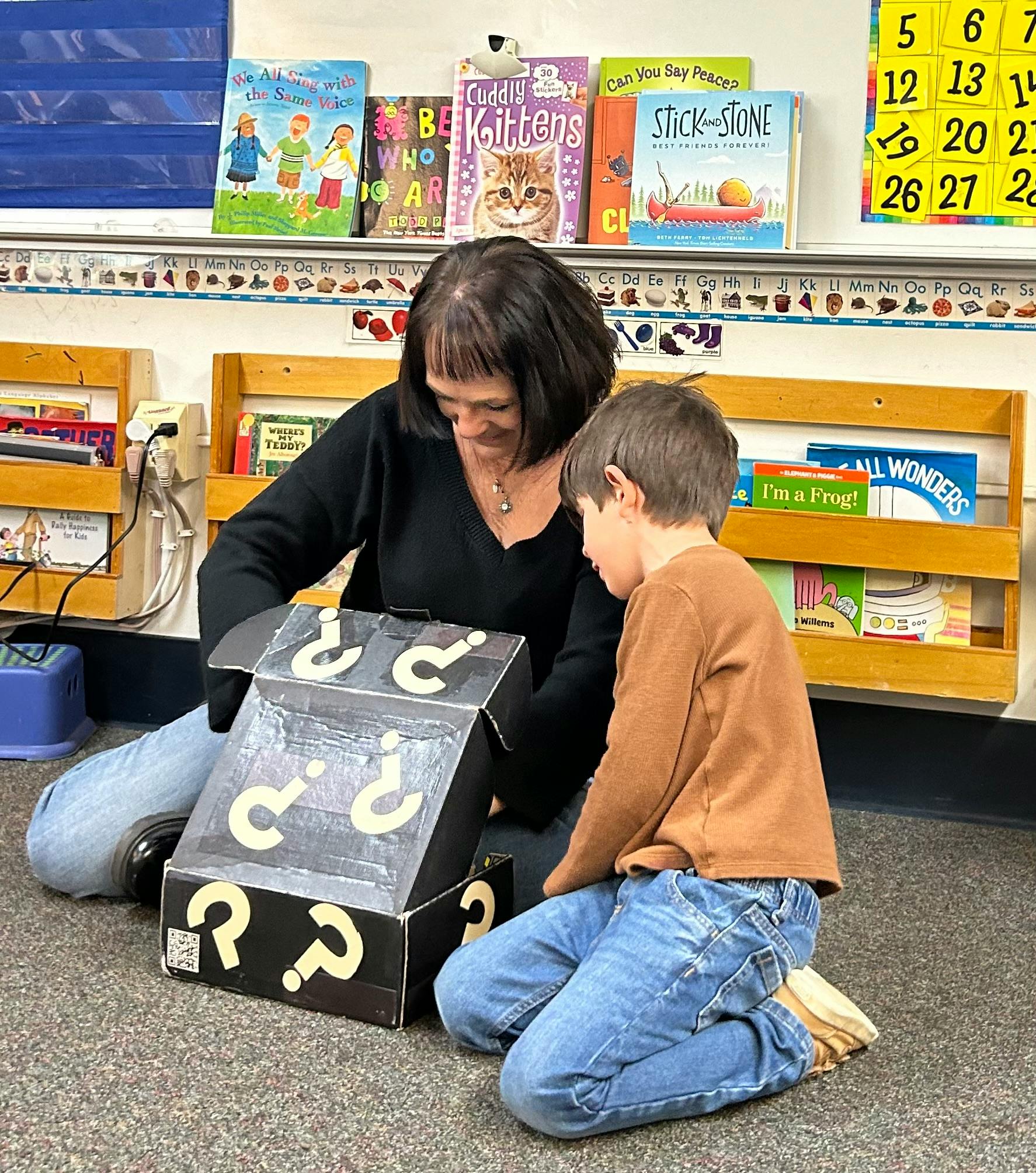 Person and child looking into a box with question marks on it