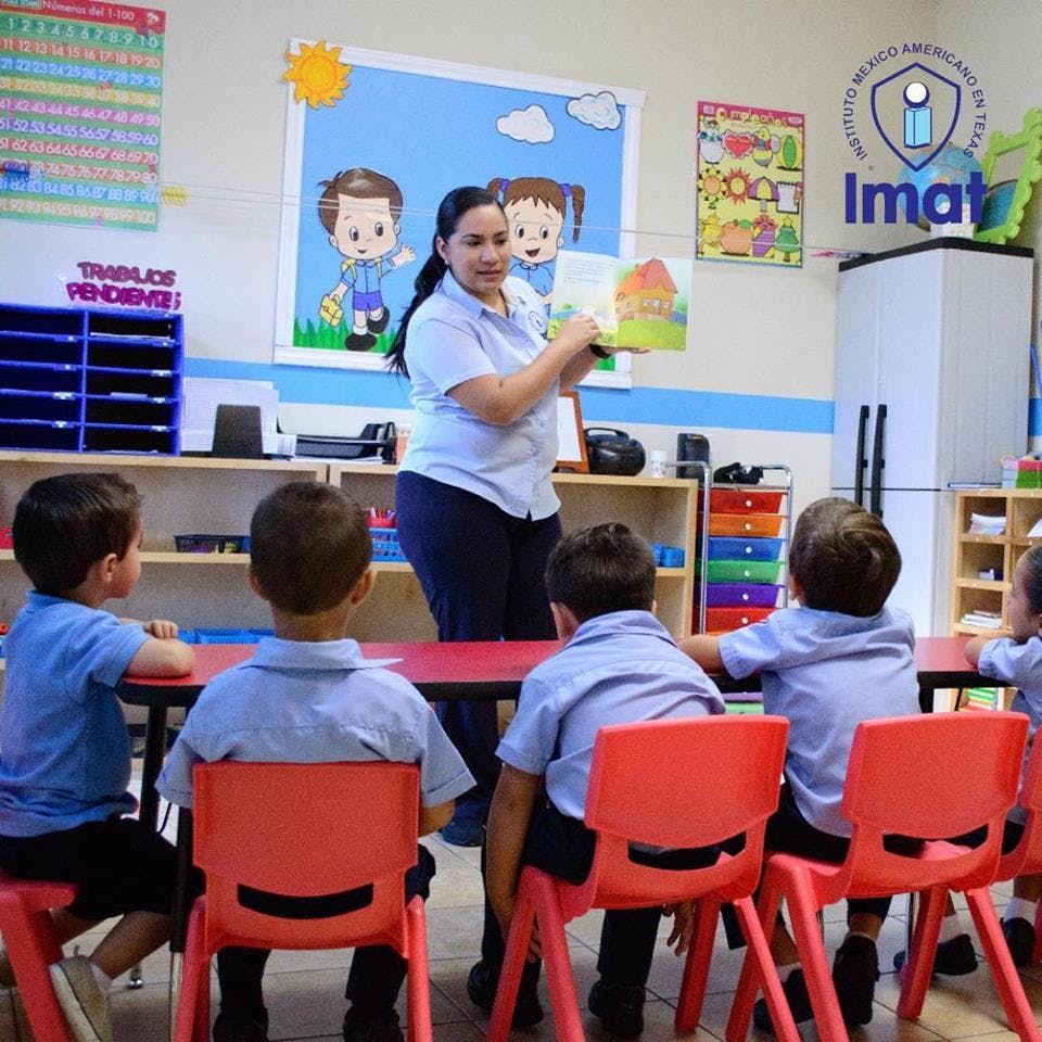 Person reading a book to children in a classroom