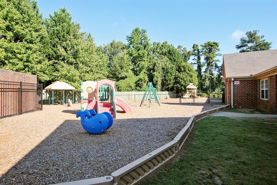 Outdoor playground with slides, swings, and a blue whale spring rider