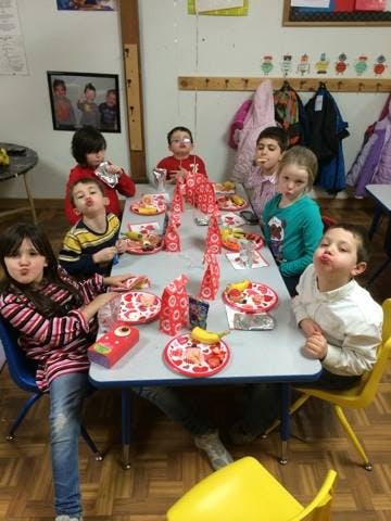 Children sitting at a table with plates of food