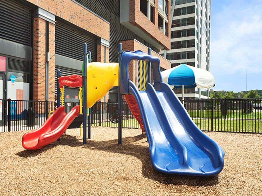 Playground with two slides, one red and one blue, with a yellow tunnel slide